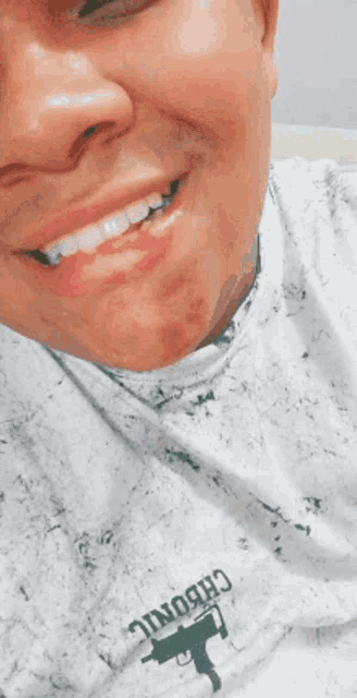 a man wearing a shirt that says chronic on it smiles
