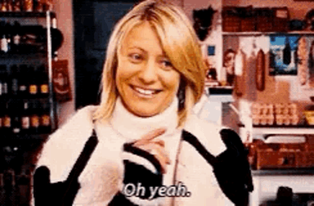 a woman in a turtleneck sweater is smiling and saying `` oh yeah '' .
