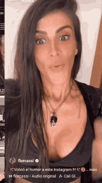 a woman wearing a black top and a black necklace is making a face