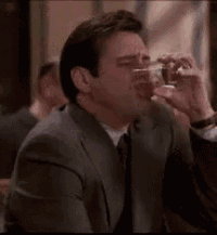 a man in a suit and tie is smoking a cigarette .