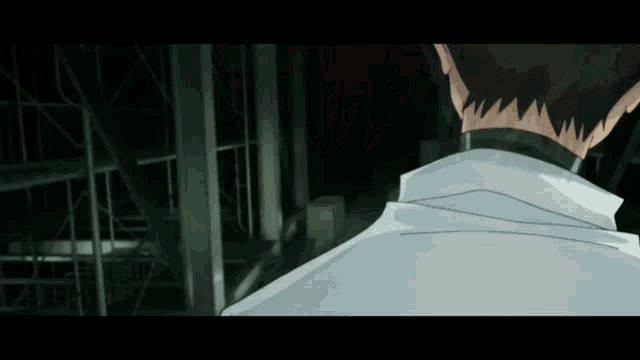 a man in a white coat stands in the dark