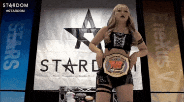 a woman stands in front of a sign that says stardom