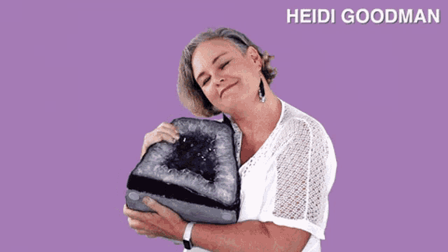heidi goodman is holding a large piece of amethyst in her hands