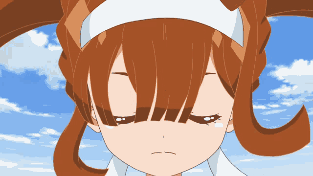 a close up of a girl 's face with her eyes closed against a blue sky
