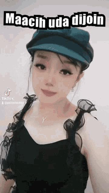 a woman wearing a hat with the words maacih uda dijoin on the bottom
