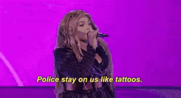 a woman is singing into a microphone on a stage .