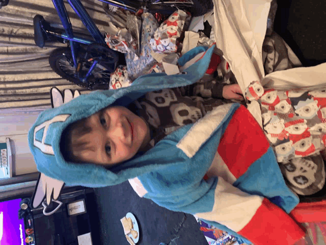 a little boy wearing a captain america hooded blanket is smiling