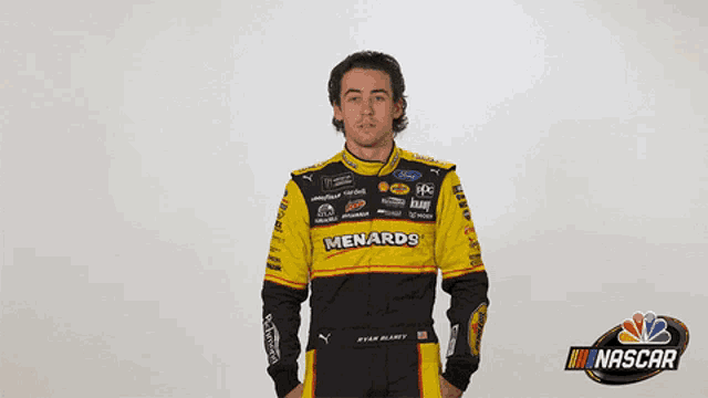 a man wearing a yellow and black menards racing suit says wow