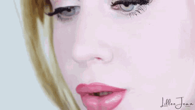 a close up of a woman 's face with red lipstick on her lips .