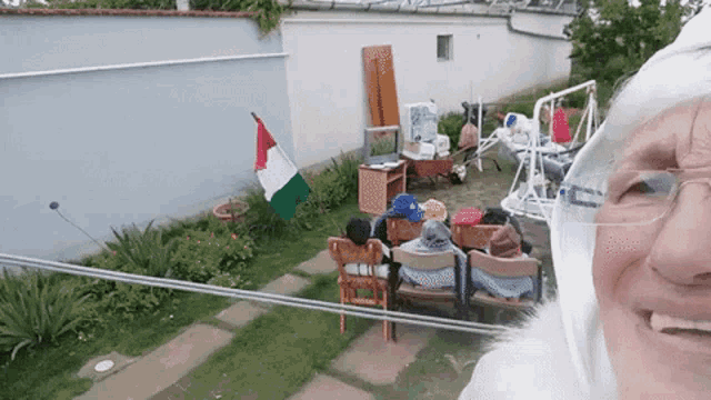 a group of people sitting in chairs in a backyard
