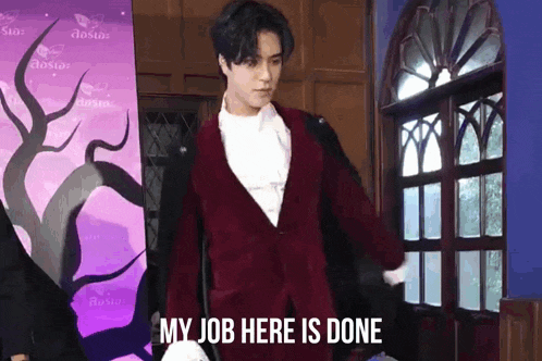 a man in a red suit is standing in front of a window with the words my job here is done below him