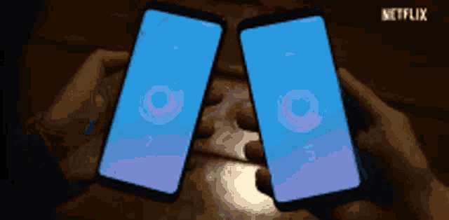 a person is holding two phones in their hands with netflix written in the corner