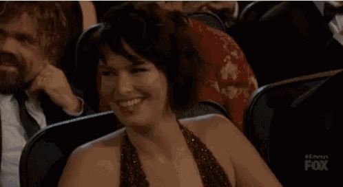 a woman in a dress is smiling while sitting in a fox tv audience