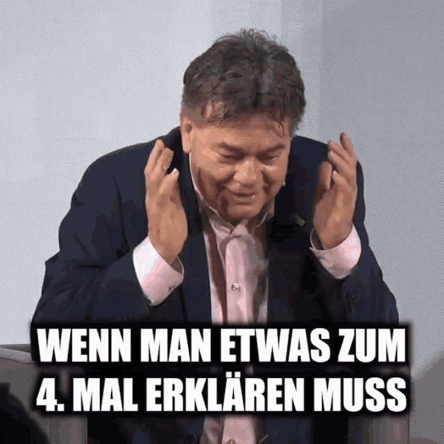 a man in a suit and pink shirt says wenn man etwas zum 4. mal erklaren muss