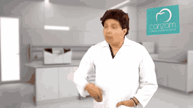 a man in a lab coat stands in front of a sign that says conzam clinica odontologica