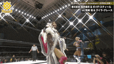 a woman in a fur coat stands in a wrestling ring with the words world beauty showdown on the bottom