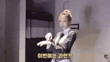 a woman in a suit and tie is standing in a room with chinese writing on the bottom