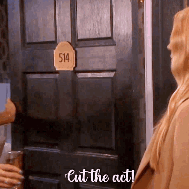a woman is standing in front of a door with a sign that says 514