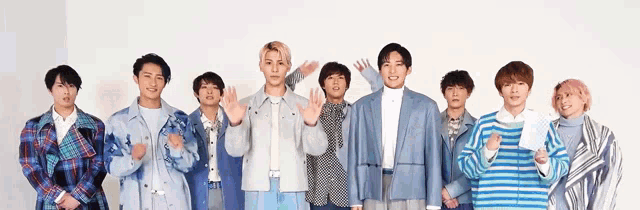 a group of young men are standing next to each other in a row .