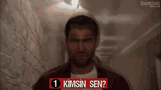 a man stands in a hallway with a sign that says 1 kimsin sen on it