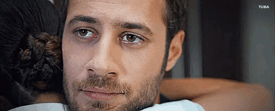 a close up of a man 's face with a woman 's head on his shoulder .