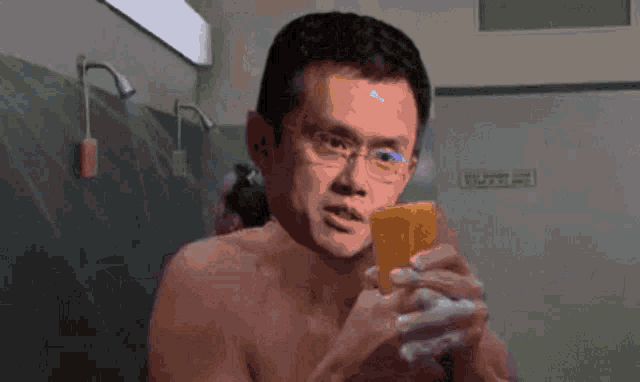 a man without a shirt is holding a piece of orange soap