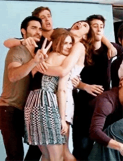 a group of people are posing for a picture and one of them is giving the peace sign