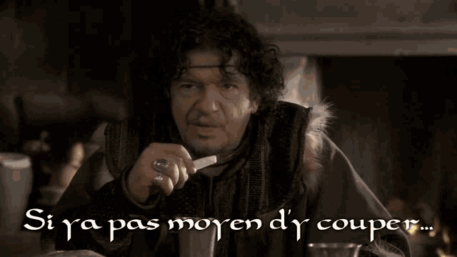 a man with curly hair is pointing at the camera with the words si ya pas moyen d ' couper written on the bottom