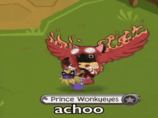 a cartoon character with red wings is standing on a grassy field .