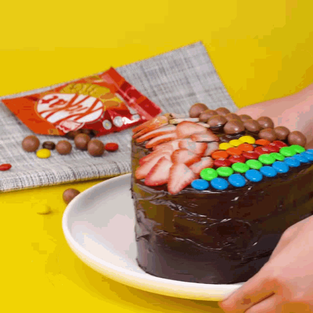 a chocolate cake with strawberries and m & ms on top