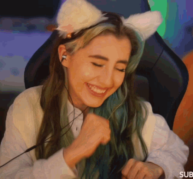 a woman wearing a cat ear headband and headphones smiles