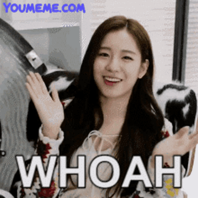 a woman is smiling and waving her hands with the words whoah behind her
