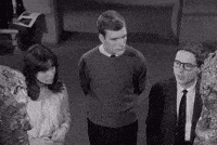 a man and a woman are standing next to each other in a black and white photo .