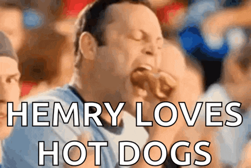 a man is eating a hot dog with the caption " henry loves hot dogs "