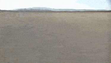 a red car is driving on a dirt road in the desert