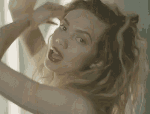 a woman with red lips is looking at herself in a mirror