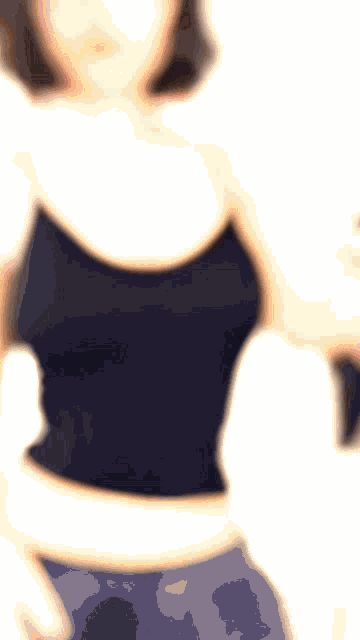 a girl wearing glasses and a black tank top is flexing her muscles
