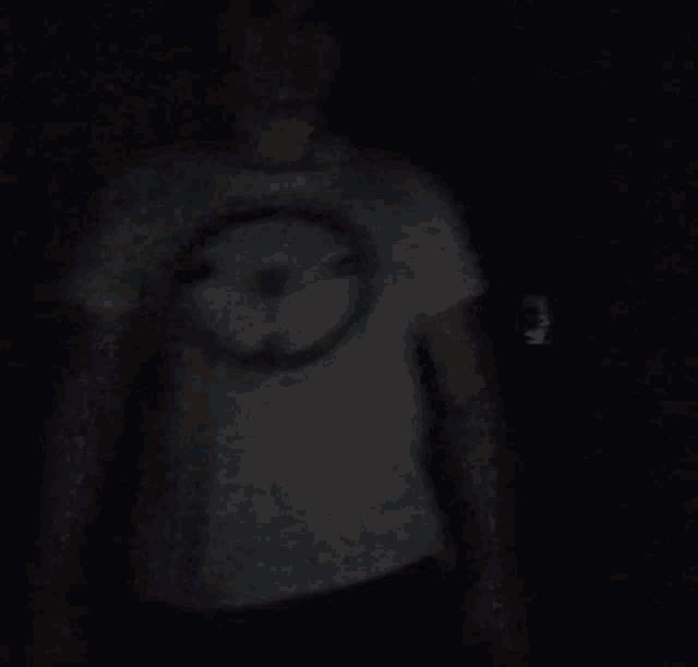 a man wearing a white shirt with a circle on it