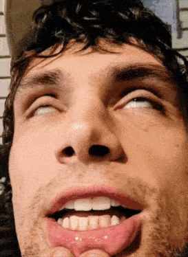 a close up of a man making a funny face with his eyes closed