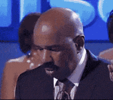 a bald man with a mustache wearing a suit and tie .