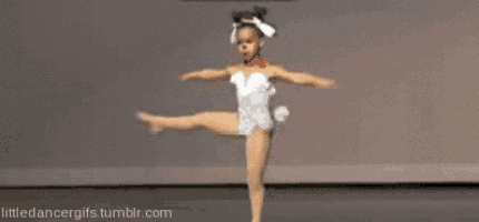 a little girl in a white leotard is doing a dance routine on a stage .