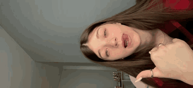 a woman with long brown hair making a funny face