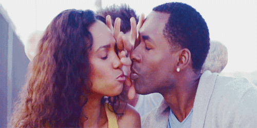 a man and a woman are kissing with their hands on each other 's faces