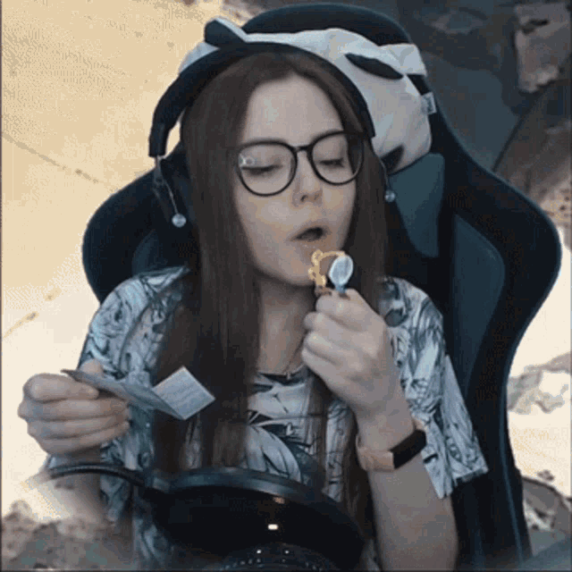 a woman wearing glasses and headphones is eating a snack