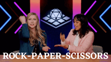two women are sitting at a table with the words rock-paper-scissors written on the bottom
