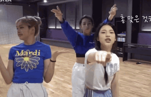 a girl wearing a blue mardi shirt is pointing