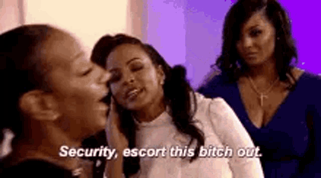 three women are standing next to each other and one of them is saying `` security escort this bitch out '' .