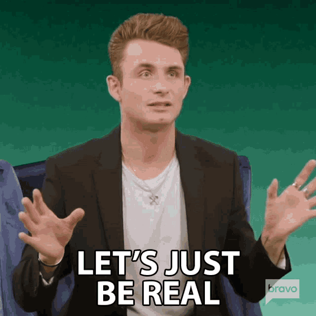 a man in a suit says let 's just be real with his hands outstretched