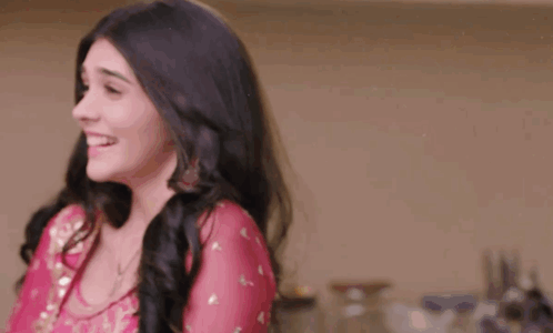 a woman in a pink dress is laughing and smiling .