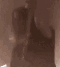 a silhouette of a person holding a sword in a dark room .